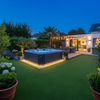 Artificial grass installed around hot tub in modern UK garden