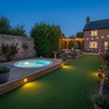 Artificial grass installed around hot tub in modern UK garden