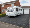 Load bearing rubber grass mats supporting caravan on grass driveway