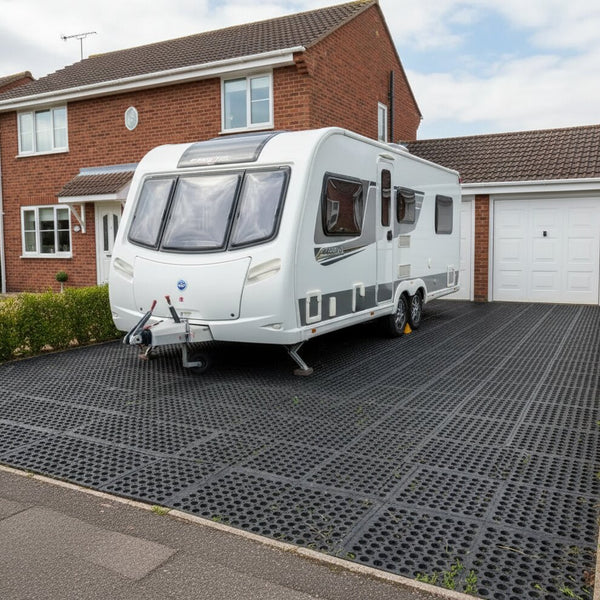 Load bearing rubber grass mats supporting caravan on grass driveway