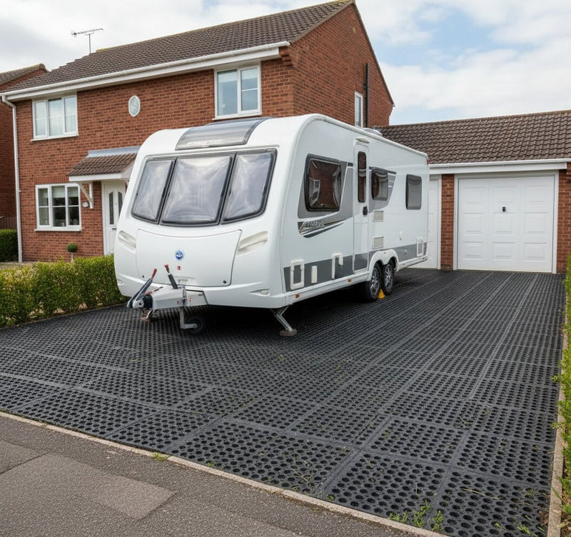 Load bearing rubber grass mats supporting caravan on grass driveway