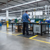 Black anti-fatigue mat with yellow safety border in industrial factory UK