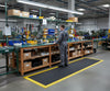 Anti-fatigue mat with yellow borders at factory workstation UK