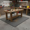 Grey protective floor mat in garage under workbench