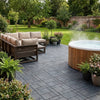 Grey recycled composite decking tiles around UK garden hot tub