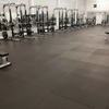 Commercial gym floor covered wall-to-wall with solid black rubber mats