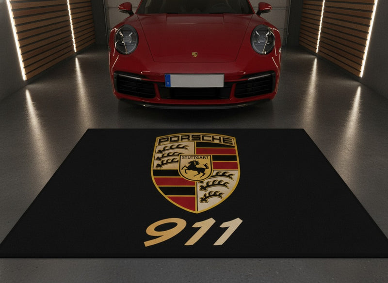 Porsche 911 garage floor mat with crest and gold 911 in front of a red 911 in a luxury home garage