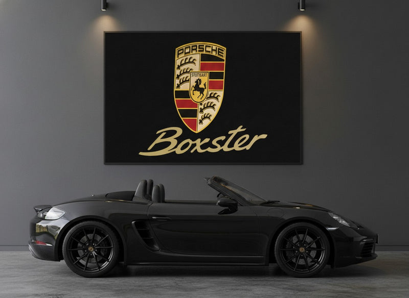 Porsche Boxster rug hung as wall art in a charcoal garage above a black 718 Boxster roadster