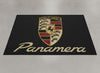 Porsche Panamera garage mat flat lay showing the full crest and gold Panamera script on black