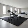 Black EVA foam exercise mats under gym equipment in professional home gym setup