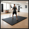 Black EVA foam exercise mats in martial arts MMA training area - person in fighting stance