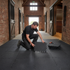Professional installation of StableFlex rubber walkway tiles 1m x 1m in UK equestrian facility, 20mm thick interlocking stable flooring